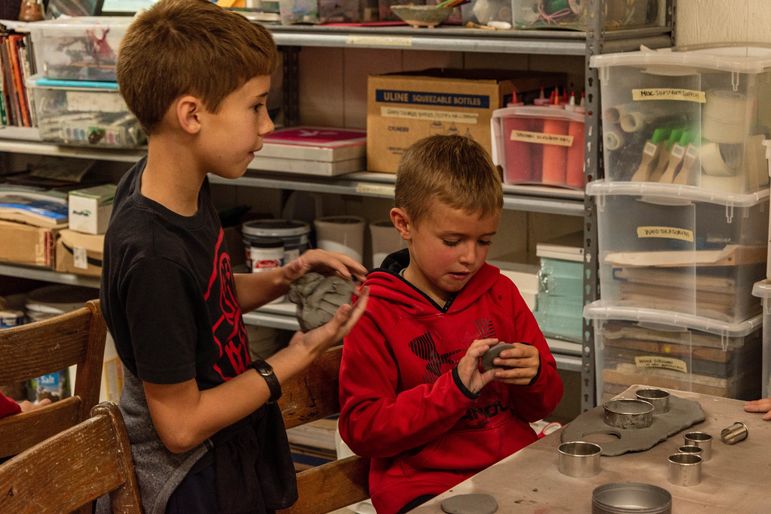 Working on finishing their pieces in pottery.
