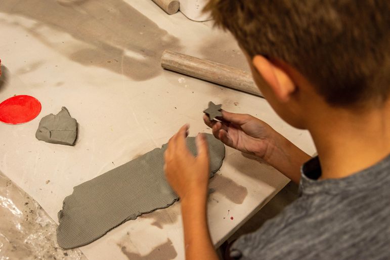 Using a slab technique to roll the clay into an even thickness, then punch out shapes with a cookie cutter for projects