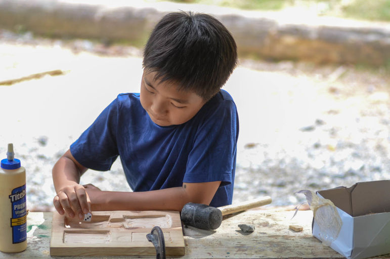 Working on his Magic game board in woodworking