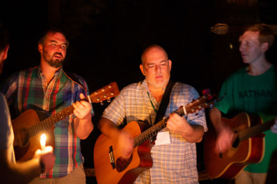 John Moll, Robert Kirby, and Nathan Newquist sharing their musical talents during Campfire