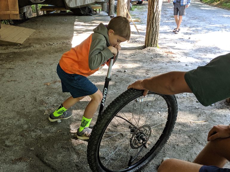 Pumping up his bike tire after practicing changing it during free-time!