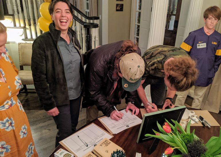 KC Collins and Mary Pharr share a laugh as Croft and Scuba sign in.